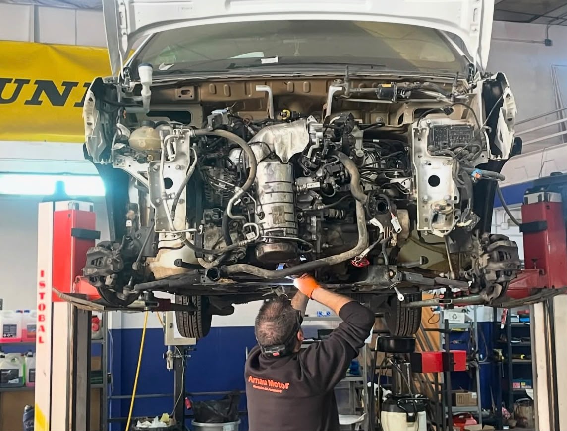 Mecánico trabajando en la parte inferior de un vehículo elevado